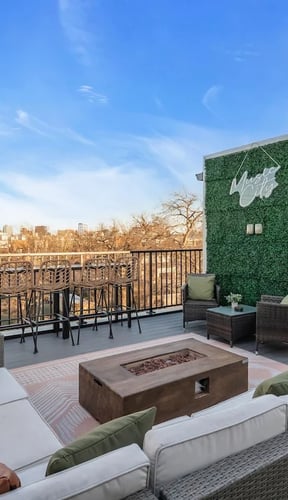 Rooftop terrace with fire pit, seating area, and Nashville city skyline at dusk
